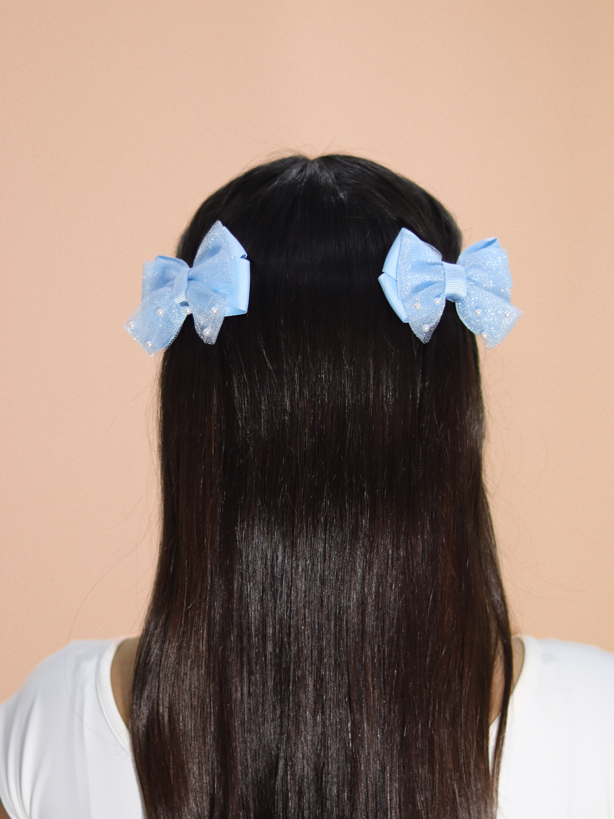 Ganchos para niñas con lazo azul claro y destellos brillantes para peinados dulces.