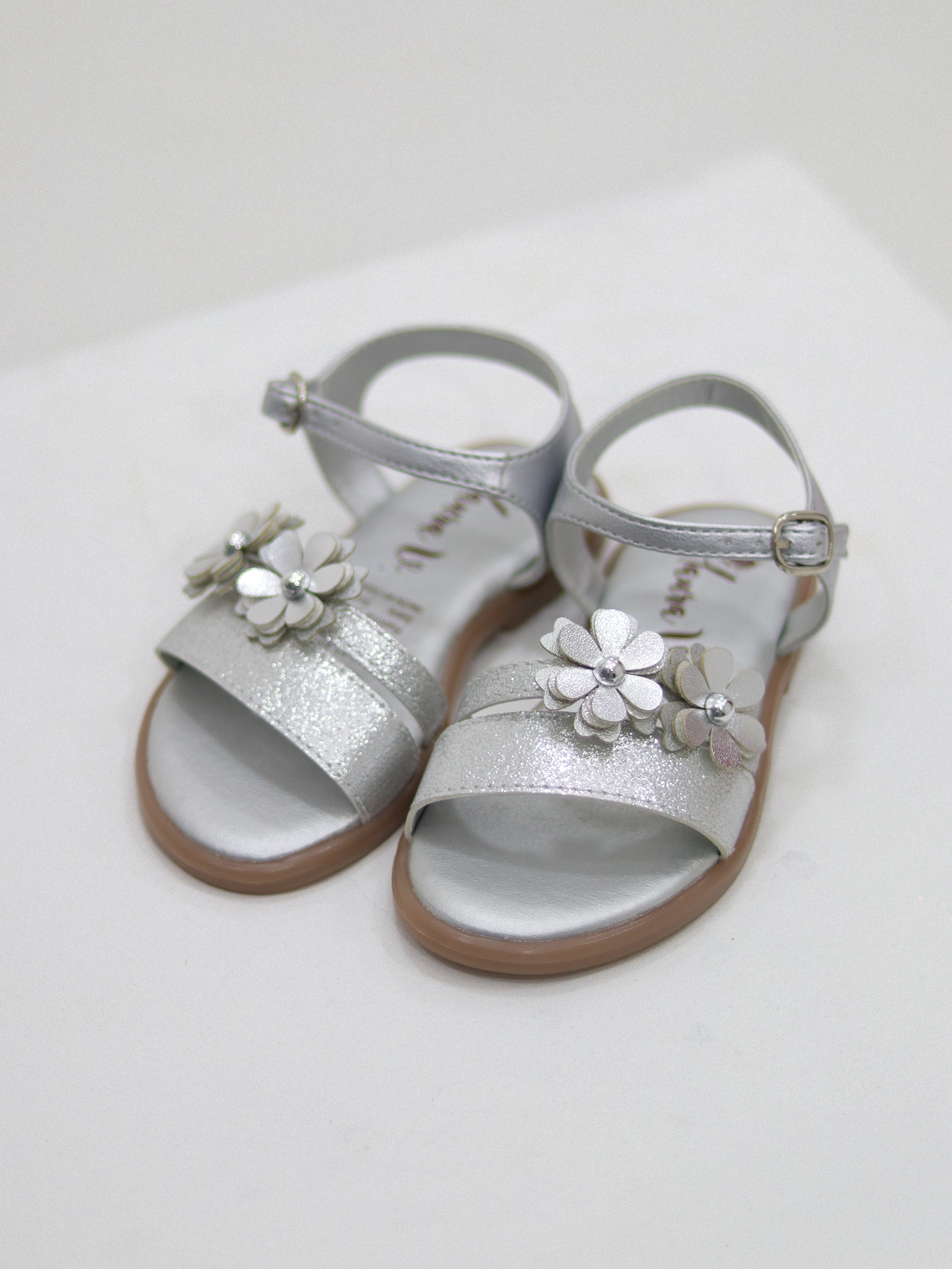 Sandalias para niñas en tono plateado con flor brillante frontal