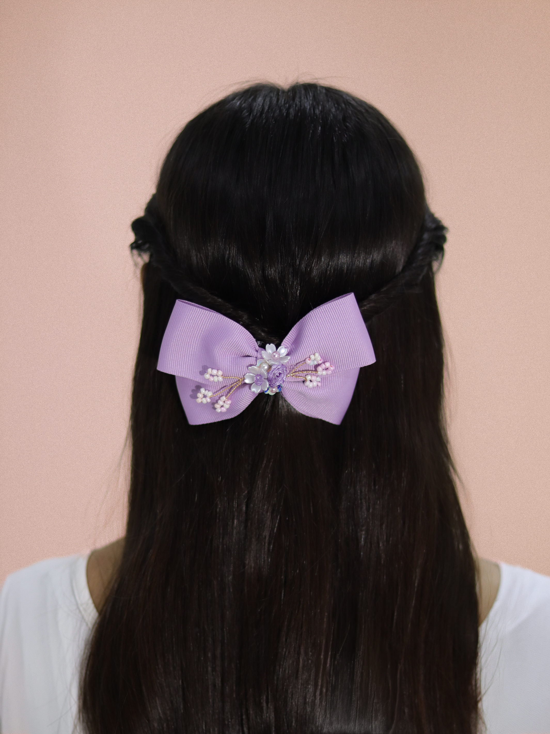 Ganchos para niñas en color lila con detalle floral y perlas decorativas.